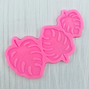 Detailed pink silicone monstera leaf mold showing three sizes for fondant and resin art