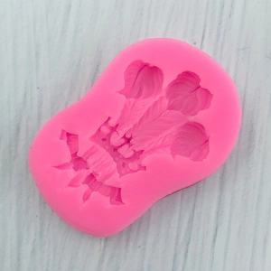Detailed close-up of pink crown and feather silicone mold for fondant cake decoration