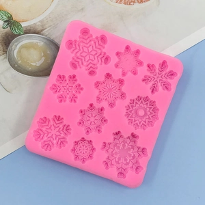 Detailed macro view of pink silicone mold with nine unique snowflake patterns for baking
