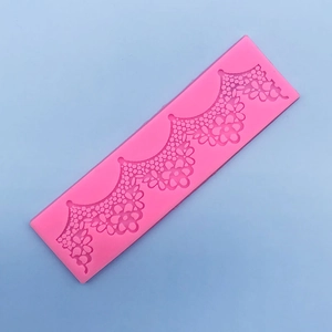Macro detail of the floral lace texture on pink silicone fondant mold for cake borders
