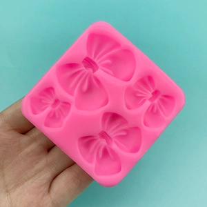 Stampo in silicone rosa con quattro cavità a fiocco per decorazione torte e cioccolato