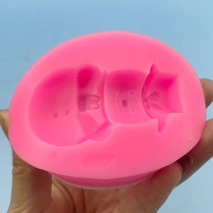 Pink silicone snowman mold with three cartoon cavities for baking and fondant crafting