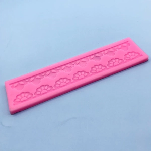 Pink silicone lace mold for fondant cake border decoration on light blue background