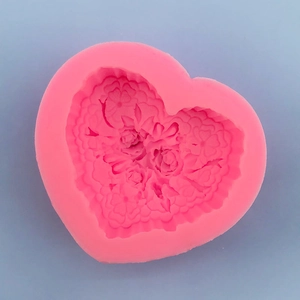 Macro shot of pink heart-shaped silicone mold with detailed rose floral textures