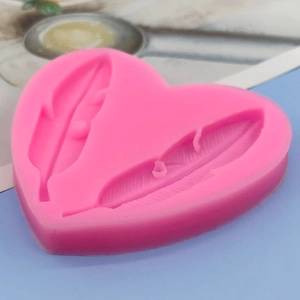 Pink heart-shaped silicone mold featuring two detailed feather patterns for cake decorating