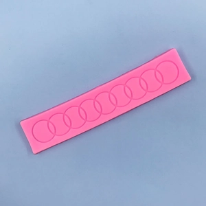 Detailed macro view of pink silicone mold with interlocking circle lace pattern for cake