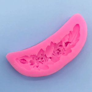 Macro shot of feather and floral patterns inside a pink silicone fondant mold