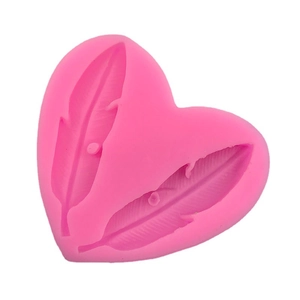 Pink heart-shaped silicone mold featuring two detailed feather patterns for cake decorating