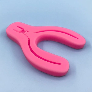 Pliers shaped pink silicone mold for DIY crafts and cake decorating on blue background