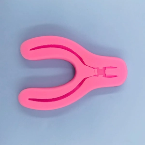 Detail view of pink silicone plier mold for DIY crafts on a light blue background