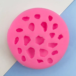 Vista dettagliata di uno stampo in silicone rosa con cavità a forma di ciottoli