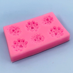 Pink 6-cavity rose silicone mold for DIY handmade cakes and chocolates on blue background