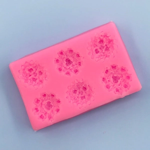 Macro detail of pink silicone mold featuring six floral rose cavities for DIY baking