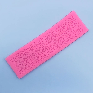 Vue macro d'un moule en silicone rose avec des motifs de dentelle florale en relief