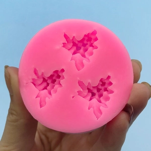 Pink silicone mold with three grape leaf cavities for DIY chocolate or wax crafting