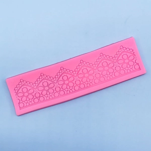 Detailed macro view of pink silicone mold featuring intricate floral lace and vine patterns