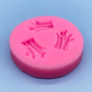 Pink silicone crown mold for DIY chocolate and cake decorating on light blue background
