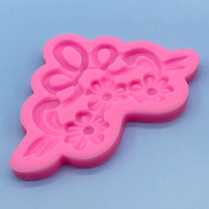 Detailed pink silicone mold featuring three daisies and butterfly outlines for DIY fondant cakes