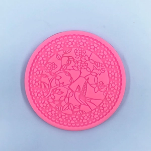 Detailed macro view of pink silicone mold with intricate floral and bird embossed patterns