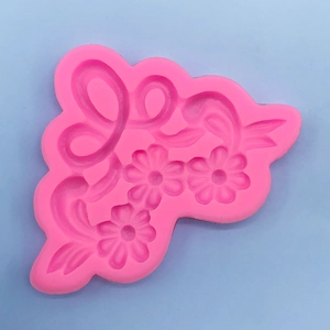Pink silicone mold with floral daisy patterns and vines for fondant cake decorating