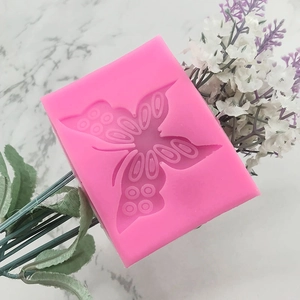 Pink butterfly silicone mold for fondant and baking on a white marble surface