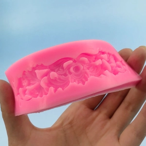 Pink silicone mold featuring intricate floral rose patterns for fondant cake decoration