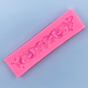 Detailed macro view of pink silicone mold with intricate European vine scroll patterns