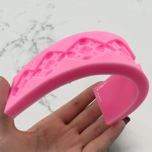 Flexible pink silicone strip mold for fondant cake borders with geometric lace patterns