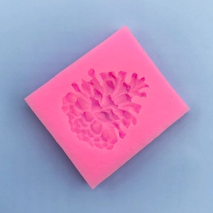 Detail view of pink silicone mold with 3D pine cone pattern for cake decorating