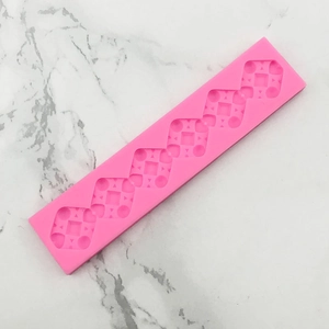 Macro detail of a pink silicone mold with geometric patterns for fondant and chocolate