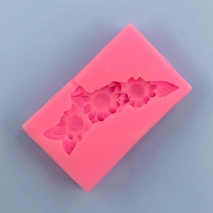 Macro detail of a bright pink silicone mold with three sunflower and leaf patterns