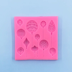 Macro detail of pink silicone mold featuring various Christmas ball and star shapes