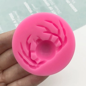 Pink silicone crab mold for chocolate, cake decoration and DIY crafts held in hand