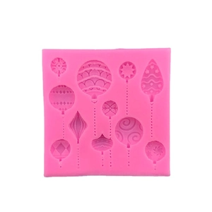 Pink silicone mold featuring various Christmas ball and heart patterns for cake decorating