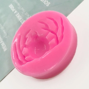 Pink crab shaped silicone mold for DIY baking and chocolate making on a minimalist background