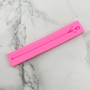 Detail showing the fine zipper texture of the pink silicone mold for cake decoration
