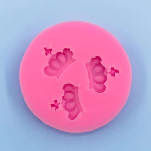 Top view of pink silicone mold with three crown shapes for DIY cake fondant and baking