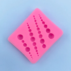 Dettaglio macro dello stampo in silicone rosa con perle per torte fondente e artigianato