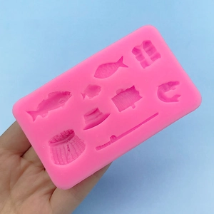 Pink silicone mold featuring fishing rod, fish, and vest shapes for fondant cake decorating