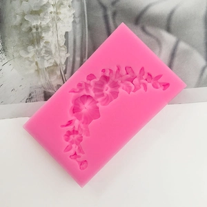 Macro detail of pink silicone mold with 3D floral garland patterns for cake decorating