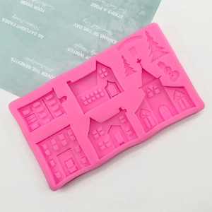 Detail of pink silicone mold featuring mini castle houses, church, and snowman designs