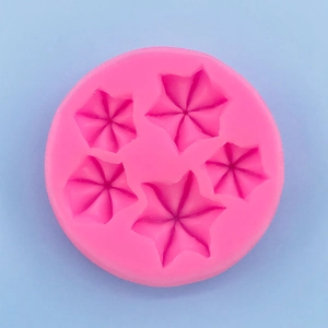 Macro detail of pink silicone mold featuring five star-shaped floral cavities for baking