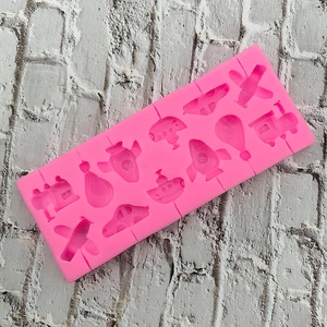 Detailed pink silicone mold featuring airplane, rocket, and car shapes for DIY candy
