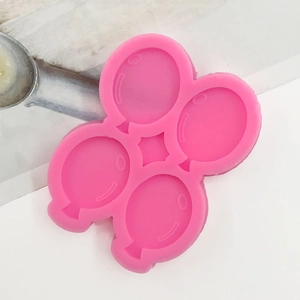 Detailed macro view of a 4-cavity pink silicone mold featuring balloon shapes for baking