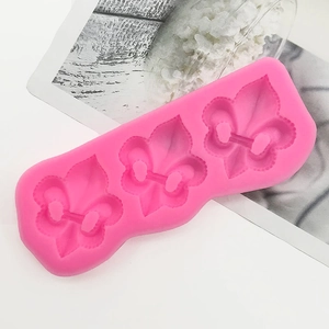 Dettaglio dello stampo in silicone rosa con tre motivi simmetrici a giglio in rilievo