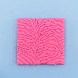 Detailed macro view of pink square silicone mold featuring 3D wave patterns for baking