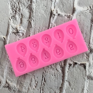 Detailed view of pink silicone mold with 0-9 balloon number shapes for cake decorating