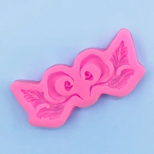 Dettaglio stampo in silicone rosa con decori a foglie barocche per decorazione torte