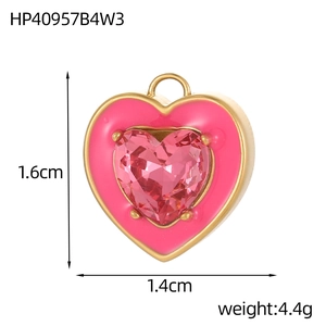 Detail van een hartvormige roestvrijstalen hanger met roze zirkoon en gouden afwerking