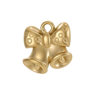 Detailed close-up of a golden metal bow and bell pendant with sand gold texture surface